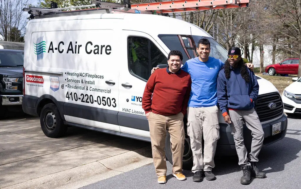 A‑C Air Care HVAC technicians team standing together in uniforms with service tools professional heating and air conditioning service