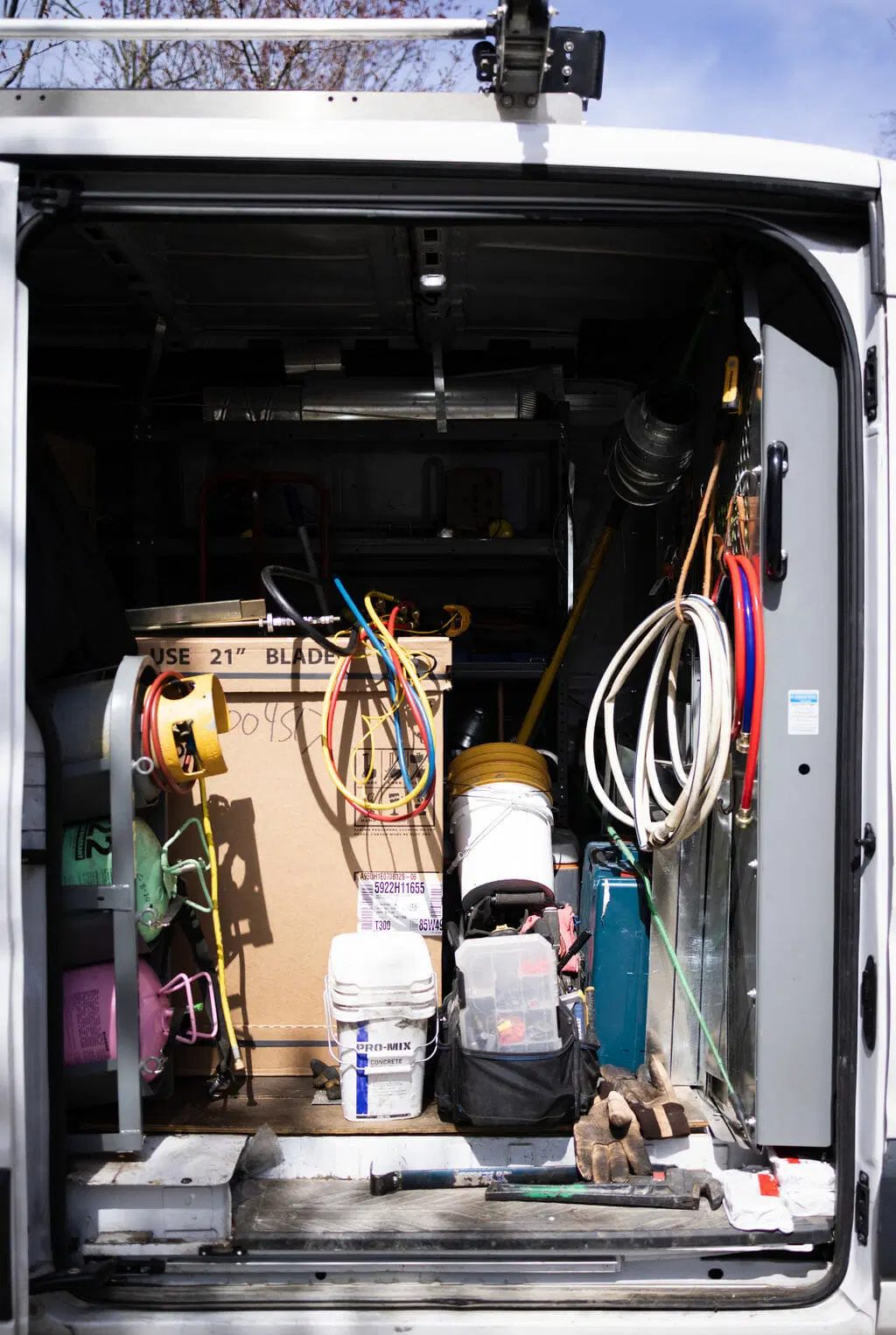 open service van rear with HVAC tools hoses and equipment organized inside professional technician vehicle