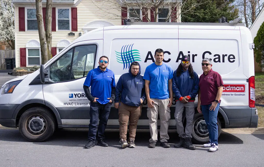 A‑C Air Care HVAC technician smiling in uniform with tools ready for air conditioning and heating service