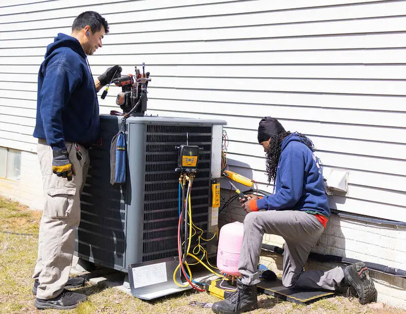 HVAC repair Columbia MD technician servicing air conditioning or heating system outdoor unit professional service
