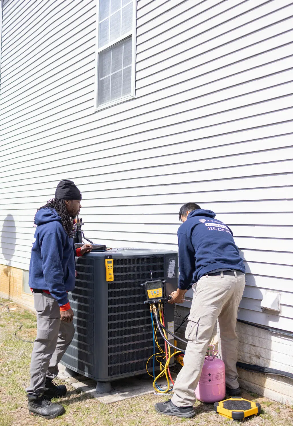 HVAC technicians repairing air conditioning unit with tools and equipment professional AC service